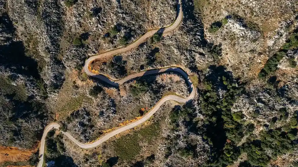 Winding mountain trail from above Winding dirt trail seen from above on a rocky mountain slope