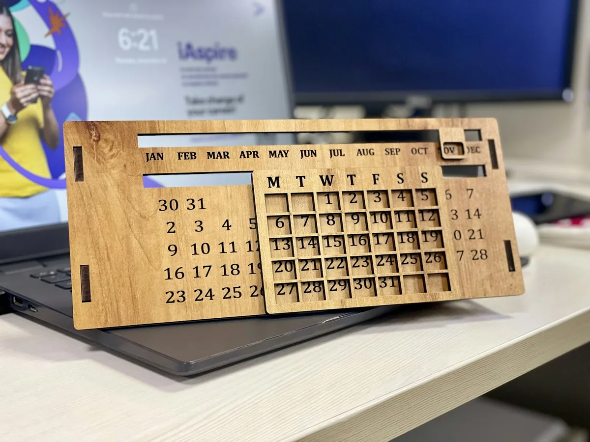 Wooden desk calendar in front of an open laptop