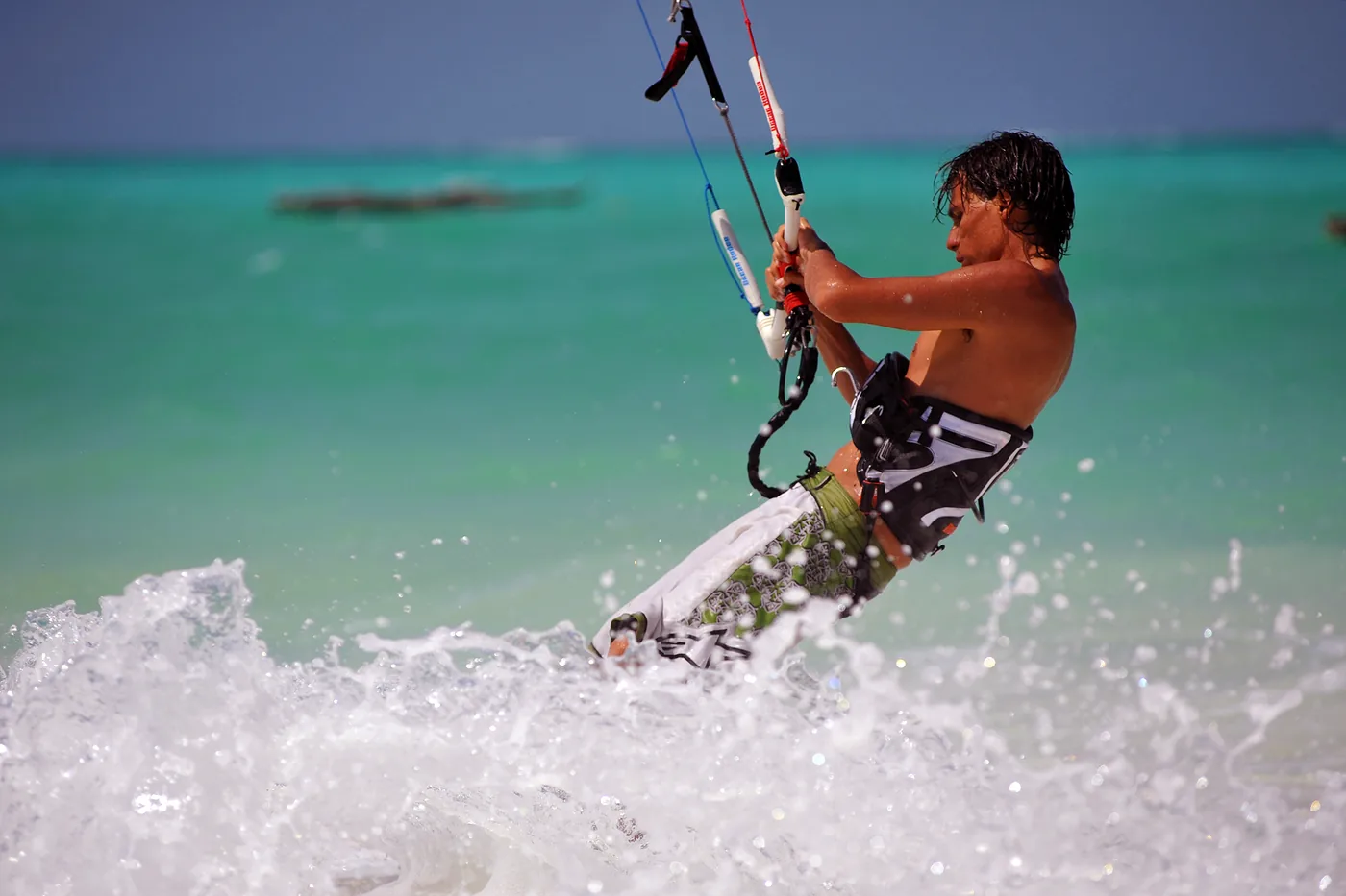 Kitesurfer holding the bar over turquoise water off Zanzibar