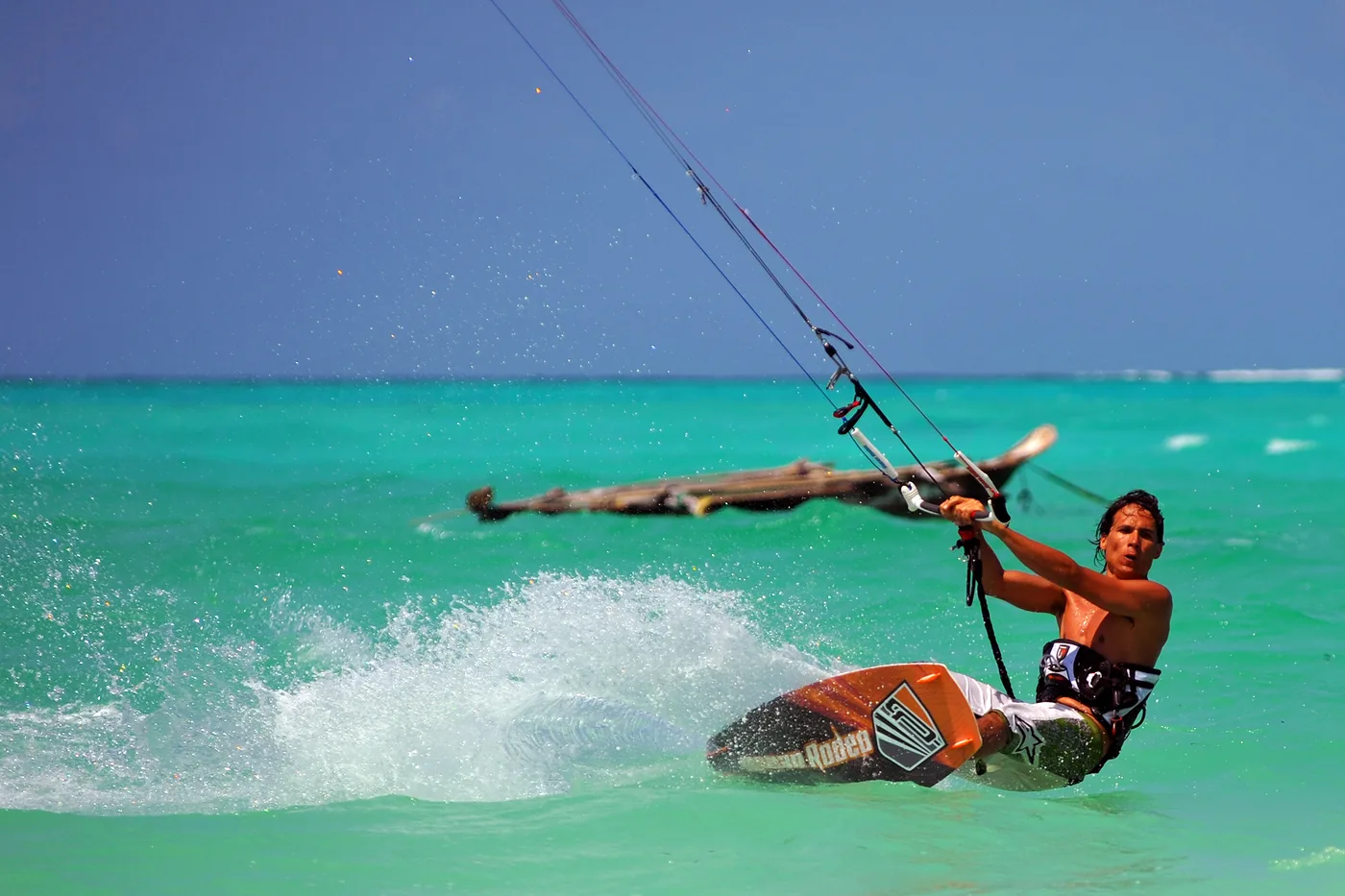 Kitesurfer carving through turquoise water off Zanzibar